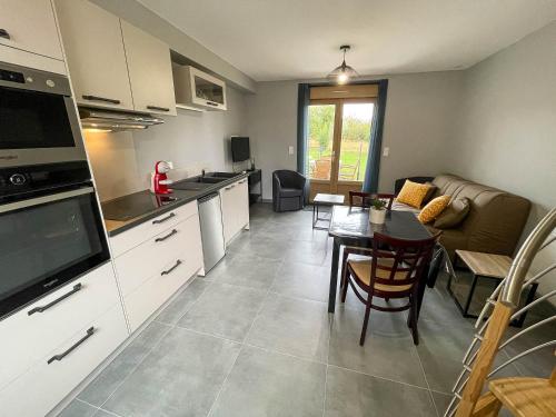 une cuisine et un salon avec une table et un canapé dans l'établissement Gîte des Ouches 3, à La Chapelle-Vieille-Forêt