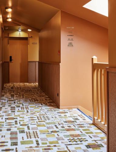 an empty hallway of a hospital with a tile floor at Hôtel Oré, Saint-Malo in Saint Malo