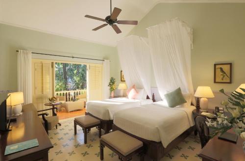 a bedroom with two beds and a ceiling fan at La Veranda Resort Phu Quoc - MGallery in Phu Quoc
