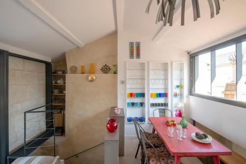 une salle à manger avec une table rouge et une fenêtre dans l'établissement Chez Domus Reattu Arles centre, à Arles