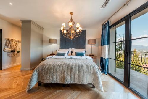 une chambre avec un grand lit et un lustre dans l'établissement Riviera Mandelieu Villa, à Mandelieu-la-Napoule