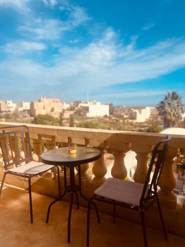 a table and chairs on a balcony with a view at Narcisa Farmhouse B&B in Nadur
