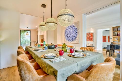 une salle à manger avec une longue table et des chaises dans l'établissement KDL - grande maison proche de Paris, à Boulogne-Billancourt
