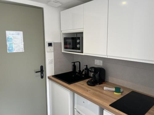 a kitchen with a sink and a microwave at Résidence Claire Roman in Valence