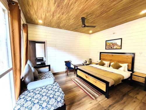 a bedroom with a bed and a desk in it at Vedant Valley Resort, Kund-Guptkashi, By Himalayan Eco Lodges in Rudraprayāg