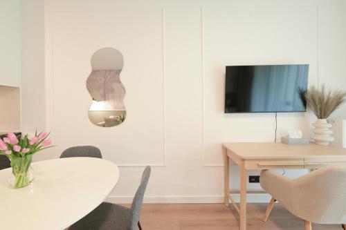 a dining room with a table and chairs and a tv at Apartamenty Florina Q4Apartments in Łeba