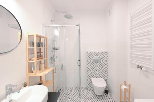 a bathroom with a shower and a toilet and a sink at Apartamenty Florina Q4Apartments in Łeba
