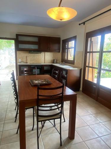 a kitchen with a wooden table and chairs at Amazing seaside beach home in the best location in Agios Ioannis Pelio