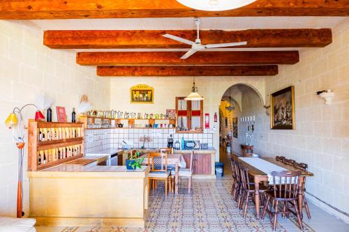 a kitchen with wooden ceilings and a table and chairs at Narcisa Farmhouse B&B in Nadur