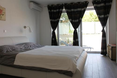 sypialnia z łóżkiem i dużym oknem w obiekcie Apartments Mala w mieście Cavtat