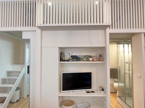 un salon avec une télévision sur un mur dans l'établissement Studio plein centre, à Cauterets