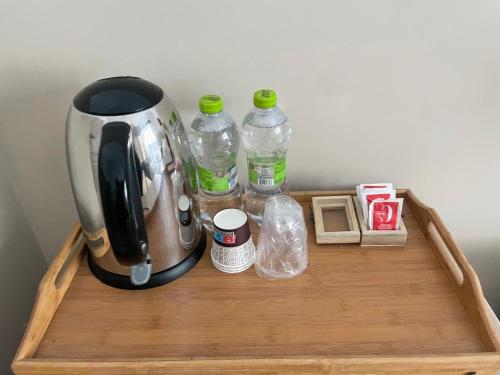 una macchina per il caffè e bottiglie d'acqua su un vassoio di legno di Next Stop Vatican Guest House a Roma