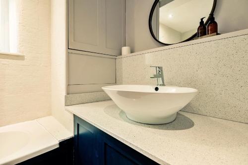 a bathroom with a white sink and a mirror at Finest Retreats - Hendy Cottage in Stroud