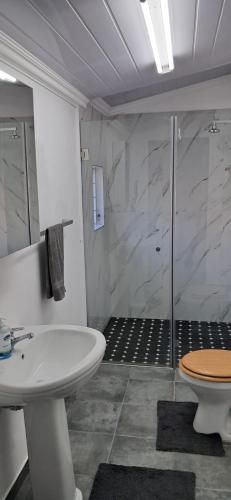 Un baño con ducha, lavabo e inodoro. en Strand Overnight - 24 Hour check-in - close to major private hospitals - sleeps 1- 4 guests - self catering - quiet neighborhood - week night low rate for single guest - weekends min 2 nights, en Strand