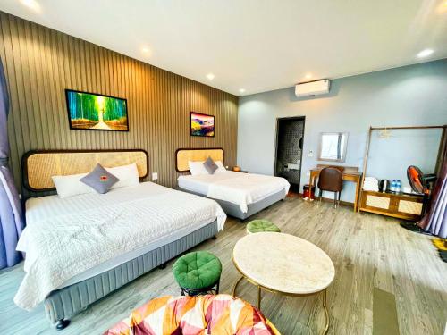 a hotel room with two beds and a table at Sunset Homestay Villa Tam Đảo in Tam Ðảo