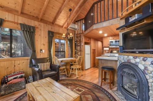 a living room with a fireplace in a log cabin at The Cozy Cub Cabin 7 Min to Lake in South Lake Tahoe