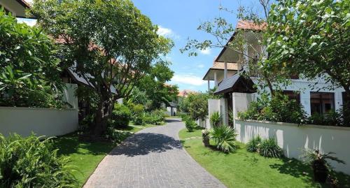 a path through a garden with trees and a house at Purama Villas Danang in Da Nang