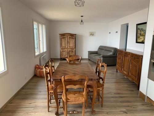 une salle à manger avec une table, des chaises et un canapé dans l'établissement Maison en Provence pour amoureux de la nature, à Saint-Geniez