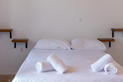 a white bed with towels on top of it at Epavlis Petrou Siwtou in Tinos Town
