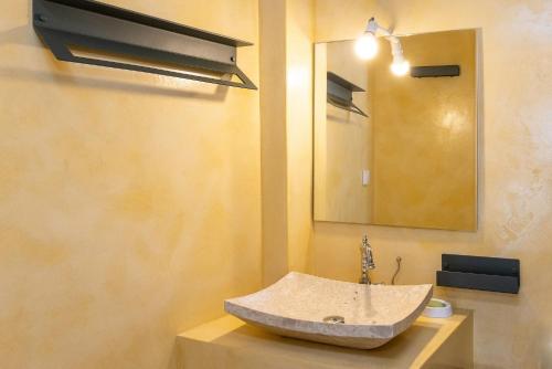 a bathroom with a stone sink and a mirror at Epavlis Petrou Siwtou in Tinos Town