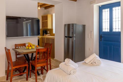 a kitchen with a table and a refrigerator at Epavlis Petrou Siwtou in Tinos Town
