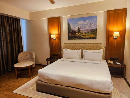a hotel room with a bed and a chair at Comfort Hotel Vista in Lucknow