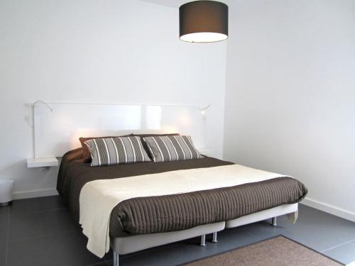 a bedroom with a bed with a white wall at Furnas Valley in Furnas
