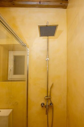 a shower in a bathroom with a light on the wall at Epavlis Petrou Siwtou in Tinos Town
