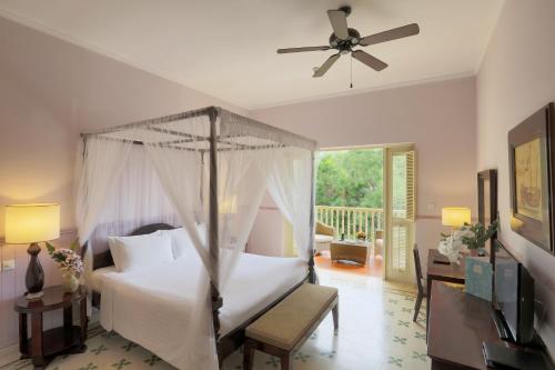 a bedroom with a bed and a ceiling fan at La Veranda Resort Phu Quoc - MGallery in Phu Quoc