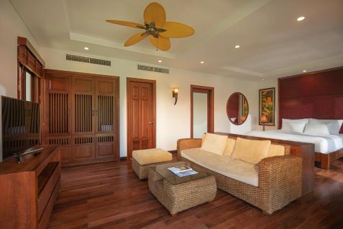 a bedroom with a bed and a living room with a couch at Purama Villas Danang in Da Nang