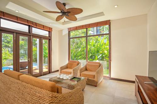 a living room with chairs and a ceiling fan at Purama Villas Danang in Da Nang