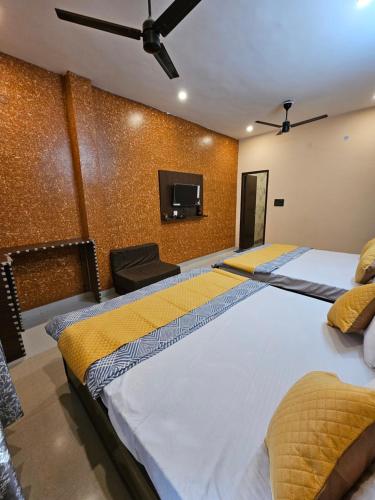 ein Schlafzimmer mit großem Bett und Flachbildfernseher in der Unterkunft Krishna's land in Vrindāvan
