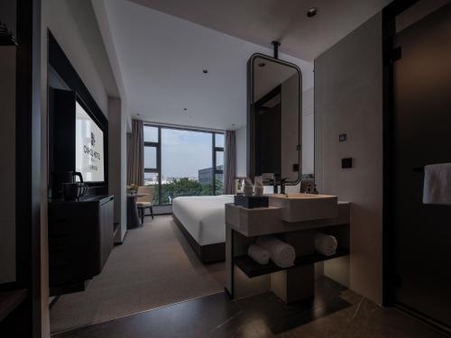 a bathroom with a bed and a sink and a mirror at 中濠悦际酒店 深圳国际会展中心店 in Shenzhen