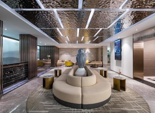 a lobby with a couch and a vase on the ceiling at 杭州西湖武林广场银泰桔子水晶酒店 in Hangzhou