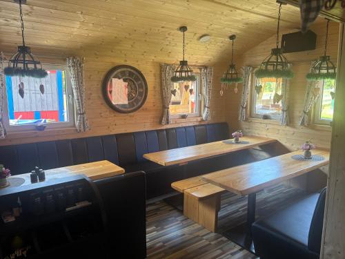 a restaurant with wooden tables and chairs and windows at Ferienhaus Spielburg in Altötting