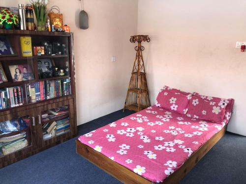 Habitación con cama y estante para libros en Shanti Dwellingss, en Thimi