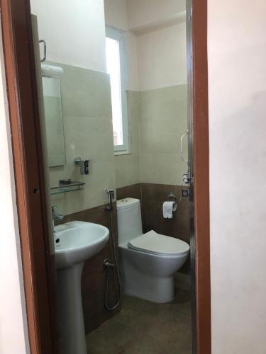 a bathroom with a toilet and a sink at Shanti Dwellingss in Thimi