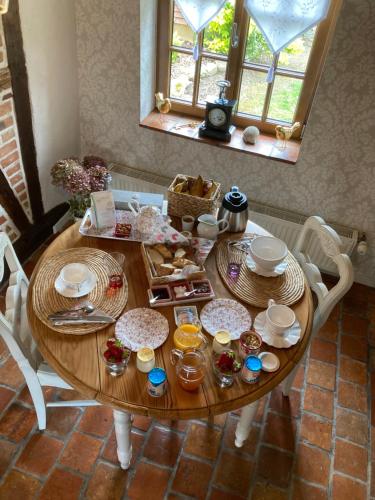 a wooden table with plates and dishes on it at La Couarderie in Tigy