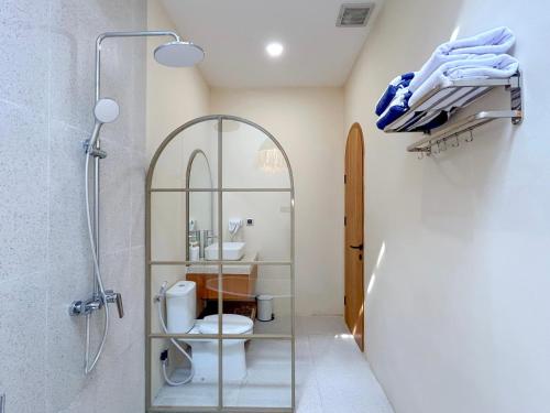 a bathroom with a shower and a toilet and a sink at Tujuan Jogja Villas - Kresna in Yogyakarta