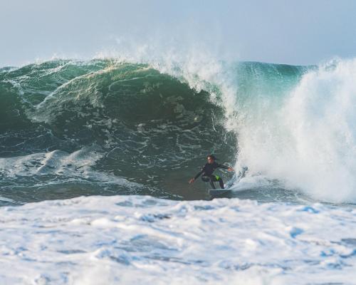 a man riding a wave on a surfboard in the ocean at Villa Med 14 in Ballito