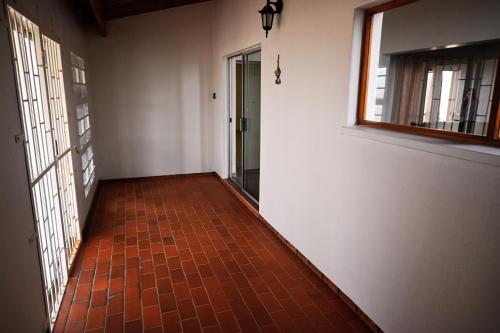 a hallway with a red tile floor and a window at 1801 on Brandberg in Hentiesbaai
