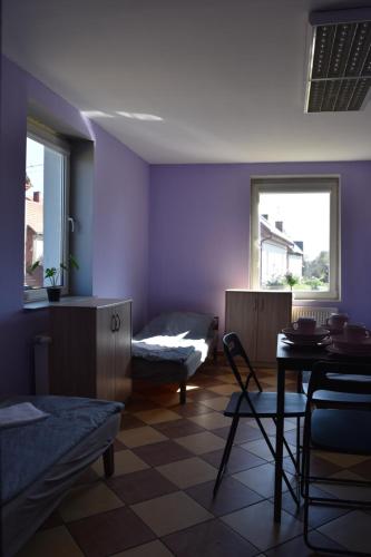 a living room with purple walls and a table and chair at Lawendowa Przystań - Dolina Baryczy in Ujeździec Mały