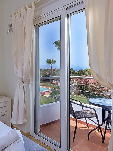 a bedroom with a sliding glass door to a balcony at Aloni Grove Retreat in Chania