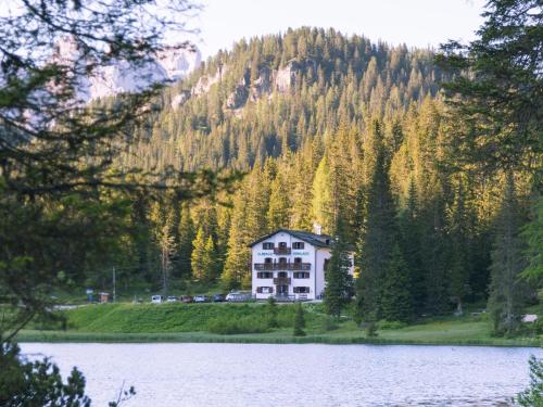 a house on a hill next to a lake at Hotel Miralago in Misurina