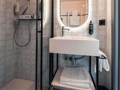 um banheiro com uma pia e um espelho em Ibis Styles Charleroi Airport Aero 44 em Charleroi