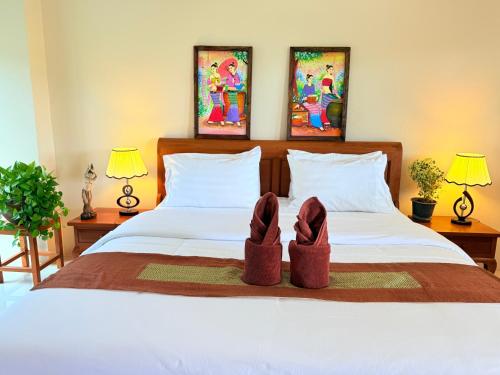 a pair of shoes sitting on top of a bed at Laph Kham House in Chiang Mai