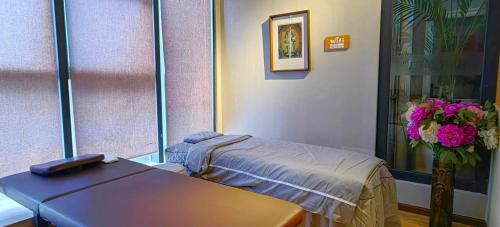 a hospital room with a table and a vase of flowers at Phoenix Dragon M.I.C.E Hotel in Kunming