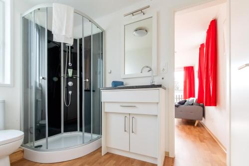 a bathroom with a glass shower and a sink at Naturcamping Lüneburger Heide - Chalets & Tiny Häuser in Soltau