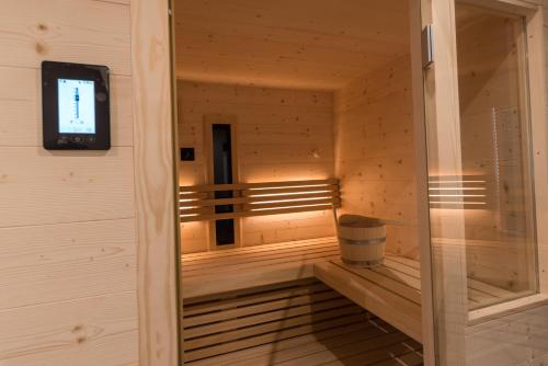 a small sauna with a trash can and a television at MESNERHOF CHALET - Ruhe, Rückzug & Südtiroler Charme mit kostenlosem Parken in der Tiefgarage in Bressanone