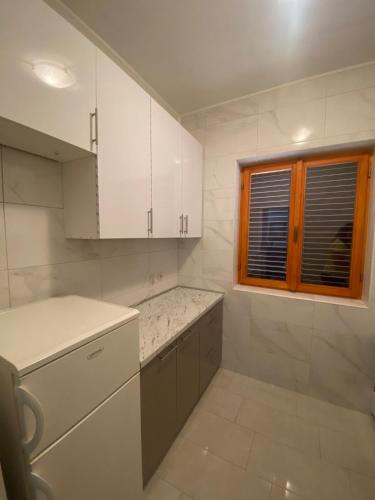 a kitchen with white cabinets and a window at Lilys Paradise in Orebić